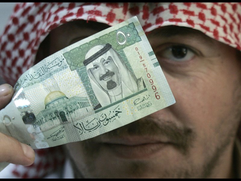 &copy; Reuters/Ali Jarekji, A man holds a 50 riyal ($13.3) note, which shows the Dome of the Rock in Jerusalem old city and Saudi&#039;s King Abdullah, in Riyadh.