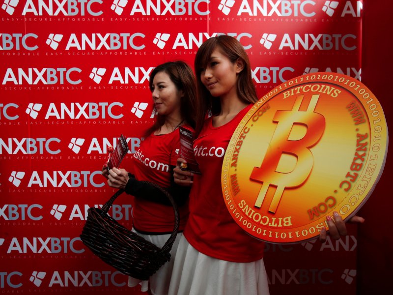 &copy; Reuters/Bobby Yip, Attendants pose with a bitcoin sign during the opening of Hong Kong&#039;s first bitcoin retail store.