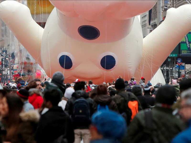 &copy; Reuters/Andrew Kelly, People watch on as the Pillsbury Doughboy is deflated following the parade.