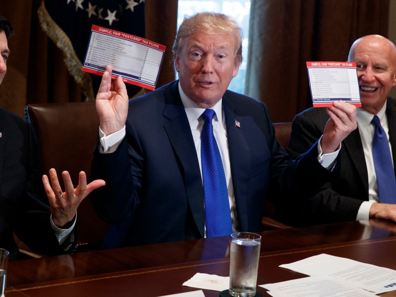 &copy; Evan Vucci/AP, Trump holds an example of what a new tax form may look like during a meeting on tax policy with Republican lawmakers in November.