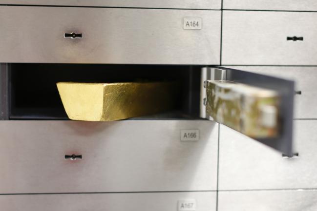 © Bloomberg. A gold bar weighing 12.5 kilograms sits inside a safety deposit box in the precious metals vault at Pro Aurum KG in Munich, Germany, on Wednesday, July 10, 2019. Gold rose for a third day after the Federal Reserve indicated that it’s preparing to cut interest rates for the first time in a decade as the global economy slows. Photographer: Michaela Handrek-Rehle/Bloomberg