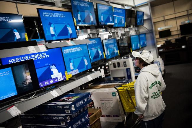 © Bloomberg. A shopper looks at televisions displayed for sale. 