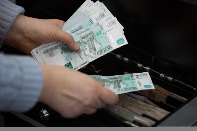 © Bloomberg. A cashier counts 1000 ruble banknotes inside a Magnit PJSC hypermarket store in Moscow, Russia, on Wednesday, Feb. 28, 2018. Billionaire Sergey Galitskiy will quit as chief executive officer of Magnit PJSC after selling 138 billion rubles ($2.5 billion) of shares--29 percent of the company--to the state-controlled VTB Group, Magnit said in a regulatory filing.
