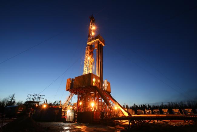 © Bloomberg. An oil drilling rig, operated by Rosneft PJSC, stands illuminated at night in the Samotlor oilfield near Nizhnevartovsk, Russia, on Tuesday, March 21, 2017. Russia's largest oil field, so far past its prime that it now pumps almost 20 times more water than crude, could be on the verge of gushing profits again for Rosneft PJSC. Photographer: Andrey Rudakov/Bloomberg