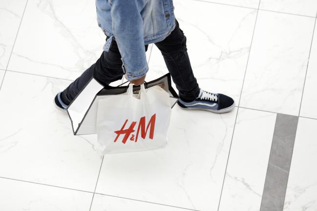 © Bloomberg. A shopper carries a Hennes & Mauritz AB (H&M) bag at the Easton Town Center Mall in Columbus, Ohio, U.S., on Tuesday, Dec. 26, 2017. Americans displayed their buying bona fides in the final run-up to Christmas, turning out in force to produce what may be the best holiday shopping season in years. Photographer: Luke Sharrett/Bloomberg