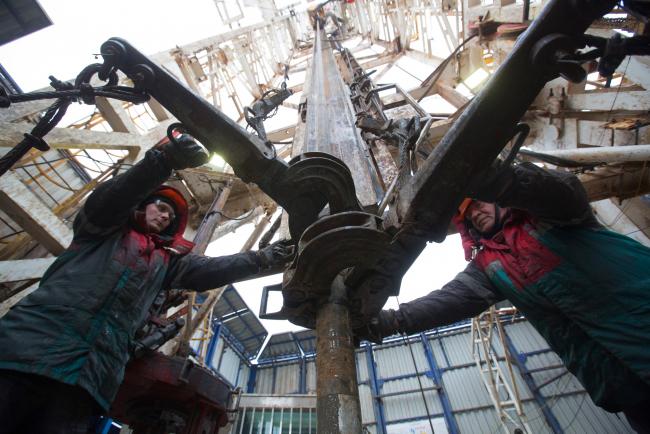 © Bloomberg. Oil workers connect gear to drilling pipes at the rotary table on a drilling rig, operated by Tatneft PJSC, on an oilfield near Almetyevsk, Tatarstan, Russia, on Tuesday, March 6, 2019. Tatneft explores for, produces, refines, and markets crude oil. Photographer: Andrey Rudakov/Bloomberg