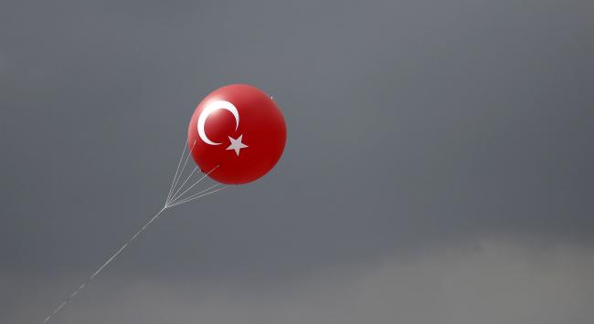 © Bloomberg. The crescent and star symbol of the Turkish national flag sits on a balloon as it flies during a 'Yes' referendum campaign rally in Yenikapi square, Istanbul, Turkey, on Saturday, April 8, 2017. With two weeks to go before a referendum that could remodel Turkey's political landscape, the central bank has pushed interest rates to the upper reaches of its monetary framework and depleted its policy tool of choice: flexibility. Photographer: Kostas Tsironis/Bloomberg