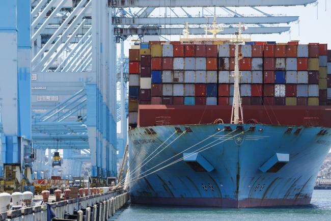 © Bloomberg. Shipping containers sit stacked on the Maersk Edinburgh cargo ship at the APM shipping terminal in the Port of Los Angeles in Los Angeles, California, U.S., on Tuesday, May 7, 2019. The terminal is planning to replace diesel trucks and human workers. It has already ordered an electric, automated carrier from Finnish manufacturer Kalmar, part of the Cargotec Corp., that can fulfill the functions of three kinds of manned diesel vehicles: a crane, top-loader and truck. 