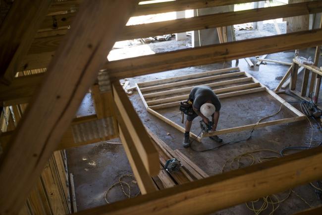 © Bloomberg. A worker saws a section of lumber inside a home under construction at the M/I Homes Inc. Bougainvillea Place housing development in Ellenton, Florida, U.S., on Thursday, July 6, 2017. 