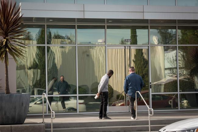 © Bloomberg. People stand outside the Apple satellite office in Sunnyvale. Photographer: David Paul Morris/Bloomberg