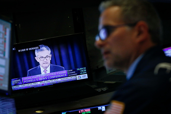 © Bloomberg. NEW YORK, NY - JUNE 19: A trader works at his post as U.S. Federal Reserve Board Chairman Jerome Powell is displayed on a monitor on the floor of the New York Stock Exchange (NYSE), June 19, 2019 in New York City. (Photo by Drew Angerer/Getty Images)