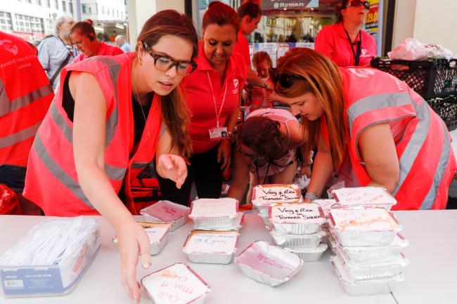 © Bloomberg. Volunteers prepare food handouts. Photographer: Luke MacGregor/Bloomberg