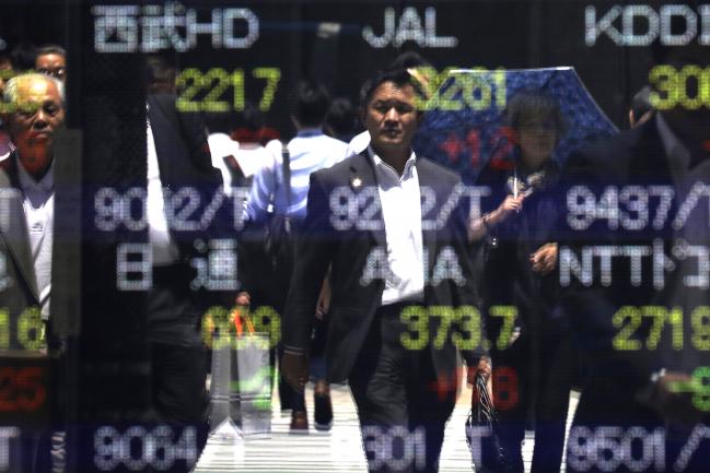 © Bloomberg. Pedestrians are reflected on an electronic stock board at a securities firm in Tokyo, Japan, on Friday, June 2, 2017. Asian stocks rallied Friday morning, with the Nikkei 225 Stock Average topping 20,000 for the first time since 2015, as the yen weakened after private American hiring data bolstered confidence in the global economy.