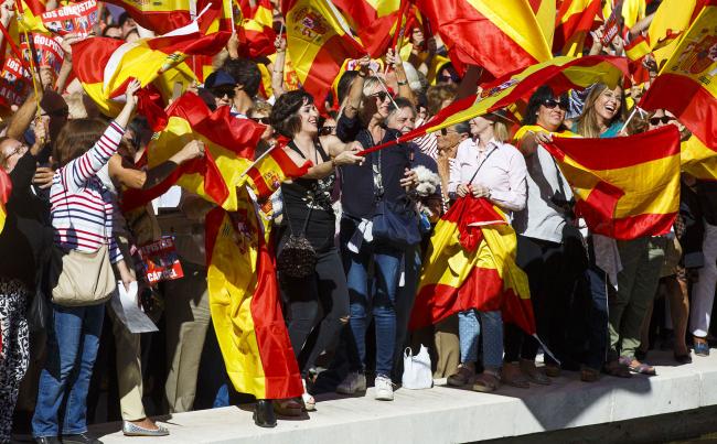 © Bloomberg. Demonstrators wave Spanish national flags in Colon Square during a protest for Spanish unity in Madrid, Spain, on Saturday, Oct. 7, 2017. Catalan President Carles Puigdemontis negotiating the text of a declaration of independence with his group's more radical partner, El Mundo newspaper has reported
