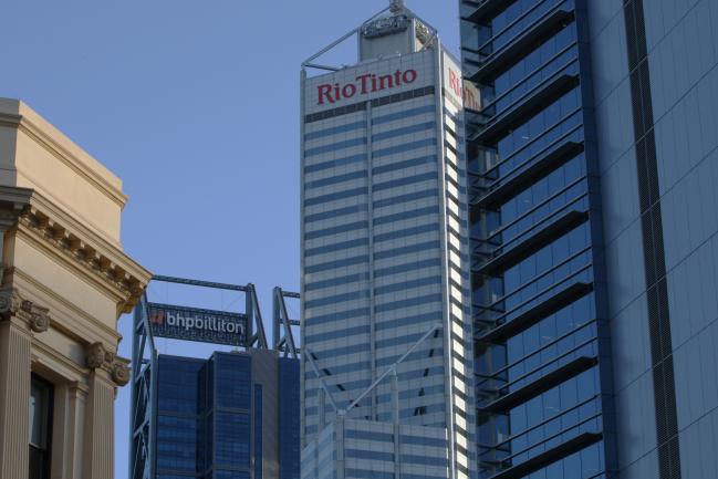 © Bloomberg. Signage for Rio Tinto Ltd. is displayed atop the Central Park Tower, center, and BHP Billitton Ltd. atop the Brookfield Place Tower, left, in the central business district of Perth, Australia, on Wednesday, April 11, 2018. Australia is scheduled to release employment figures on April 19. Photographer: Sergio Dionisio/Bloomberg