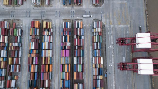 © Bloomberg. Containers sit stacked at the Yangshan Deep Water Port in this aerial photograph taken in Shanghai, China. Photographer: Qilai Shen/Bloomberg