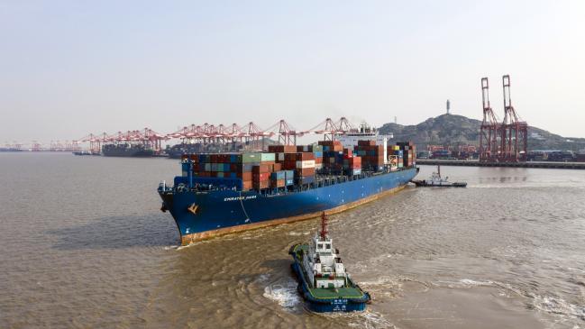 © Bloomberg. Tugboats guide the Emirates Hana container ship at the Yangshan Deepwater Port, operated by Shanghai International Port Group Co. (SIPG), in this aerial photograph taken in Shanghai, China, on Friday, May 10, 2019. The U.S. hiked tariffs on more than $200 billion in goods from China on Friday in the most dramatic step yet of President Donald Trump's push to extract trade concessions, deepening a conflict that has roiled financial markets and cast a shadow over the global economy. 