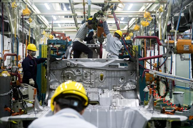 © Bloomberg. Workers assemble a vehicle at the Xpeng Motors Technology Ltd. prototype center in Guangzhou, China, on Wednesday, June 6, 2018. Though Xpeng hasn't delivered a single vehicle, doesn't own a factory and hasn't obtained a production license from the government, the Chinese electric automaker expects to raise more than $600 million this month from investors that include Alibaba, valuing it close to $4 billion, according to a person familiar with the fundraising. Photographer: Giulia Marchi/Bloomberg
