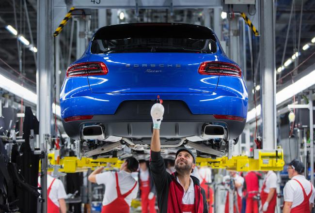 © Bloomberg. Employees work on the Porsche Macan sports utility vehicle assembly line inside the Porsche Leipzig GmbH factory, a unit of Porsche AG, in Leipzig, Germany, on Thursday, Dec. 1, 2016.  Photographer: Krisztian Bocsi/Bloomberg