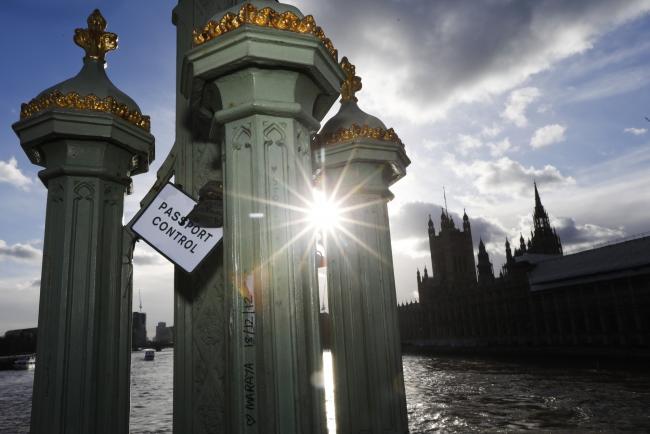 © Bloomberg. A sign reading 'Passport Control' hangs from padlocks attached to Westminster Bridge as the Houses of Parliament stands on the bank of the River Thames in London, U.K., on Tuesday, Jan. 22, 2019. The U.K.’s main opposition party is backing a plan that could open the door to a second European Union referendum, bringing the possibility of stopping Brexit a step closer. Photographer: Luke MacGregor/Bloomberg