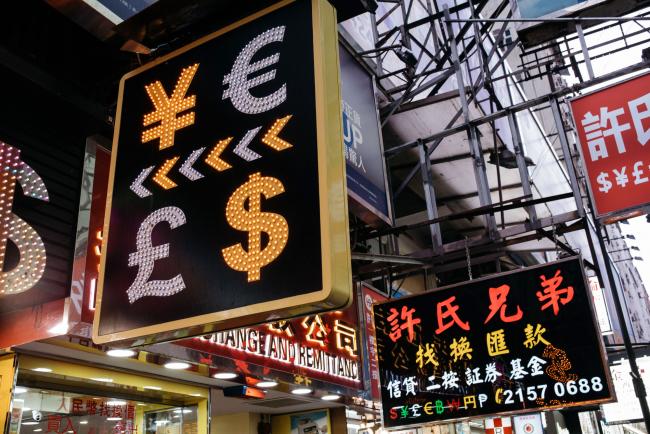 © Bloomberg. A sign featuring Japanese yen, top left, euro, top right, British pound sterling, bottom left, and U.S. dollar is displayed at a currency exchange store in Hong Kong, China, on Thursday, March 16, 2017. Hong Kong's shopping districts are dotted with money changers advertising their remittance services and conversion rates. There are 1,891 licensed money operators in the city, Hong Kong customs data show.