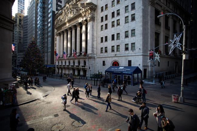 © Bloomberg. Pedestrians pass in front of the New York Stock Exchange (NYSE) in New York, U.S.