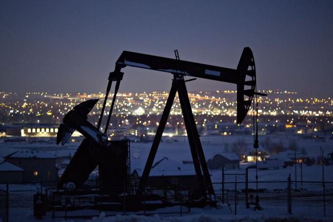 © Bloomberg. A pumpjack operates above an oil well at night in the Bakken Formation on the outskirts of Williston, North Dakota, U.S., on Thursday, March 8, 2018. When oil sold for $100 a barrel, many oil towns dotting the nation's shale basins grew faster than its infrastructure and services could handle. Since 2015, as oil prices floundered, Williston has added new roads, including a truck route around the city, two new fire stations, expanded the landfill, opened a new waste water treatment plant and started work on an airport relocation and expansion project.