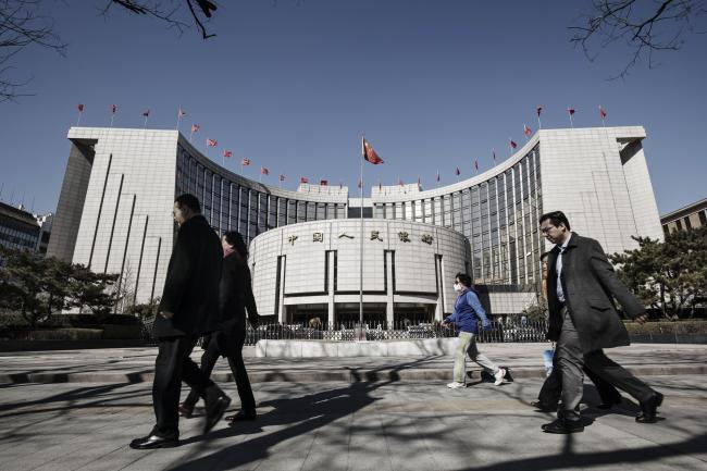 © Bloomberg. Pedestrians walk past the People's Bank of China headquarters in Beijing. 