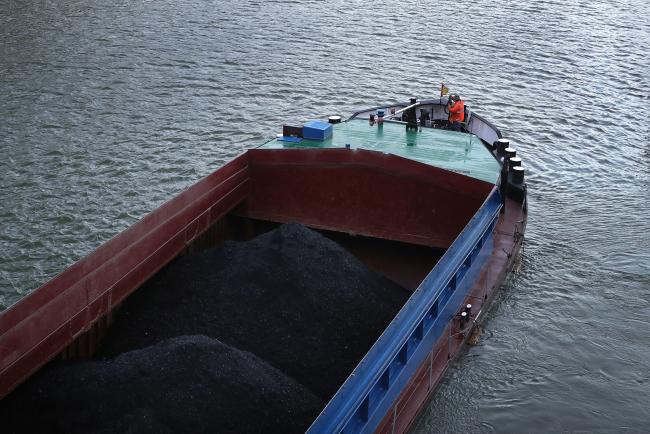 © Bloomberg. A barge transporting coal sails past the Volkswagen AG (VW) headquarters on the Mittleland canal in Wolfsburg, Germany, on Tuesday, Dec. 4, 2018. VW would support eliminating tariffs on exported cars between the European Union and the U.S., the German automaker's strategy head Michael Jost said today at the Handelsblatt auto industry conference. Photographer: Krisztian Bocsi/Bloomberg