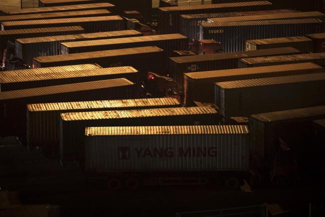 © Bloomberg. Trucks sit parked at the Yangshan Deepwater Port, operated by Shanghai International Port Group Co. (SIPG), at night in Shanghai, China on Wednesday, Jan. 30, 2019. The U.S. and China launched high-level trade talks in Washington with little indication that Beijing will bend to U.S. demands to deepen economic reforms. 