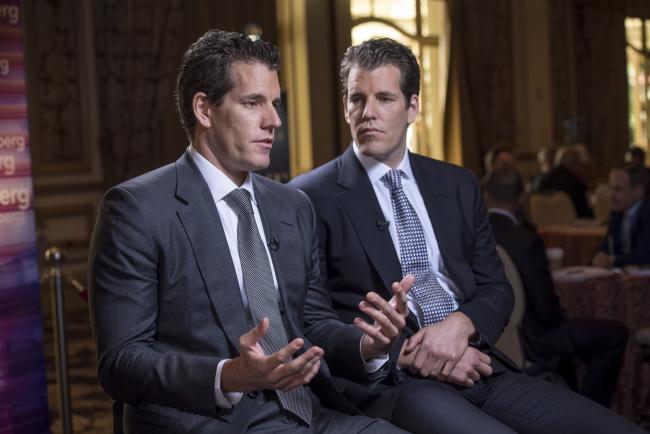 © Bloomberg. Cameron Winklevoss speaks as Tyler Winklevoss listens. Photographer: David Paul Morris/Bloomberg