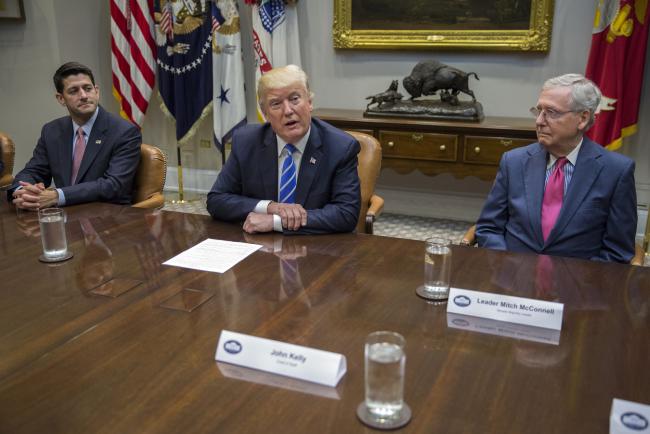 © Bloomberg. U.S. President Donald Trump speaks as Senate Majority Leader Mitch McConnell, a Republican from Kentucky, right, and U.S. House Speaker Paul Ryan, a Republican from Wisconsin, left, listen during a meeting with members of Congress and Trump's administration regarding tax reform in the Roosevelt Room of the White House in Washington, D.C., U.S., on Tuesday, Sept. 5, 2017. Congress, back from its August vacation, has less than a month to avert a default on the nations debt and avoid a government shutdown. The pressure of dealing with Harveys destruction, possible more damage from Hurricane Irma and the North Korea crisis could make a fiscal fight less likely.