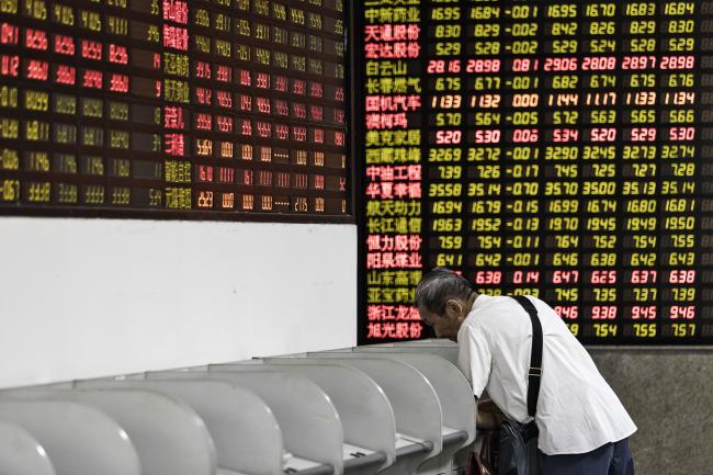 © Bloomberg. An investor stands at a trading terminal in front of electronic stock boards at a securities brokerage in Shanghai, China, on Friday, June 9, 2017. The Shanghai Composite Index rose 0.1 percent to extend a weekly gain to 1.5 percent. 