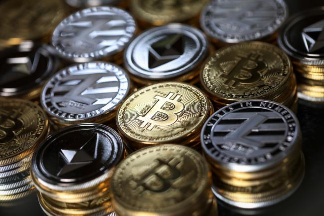 © Bloomberg. A collection of bitcoin, litecoin and ethereum tokens sit in this arranged photograph in Danbury, U.K., on Tuesday, Oct. 17, 2017.