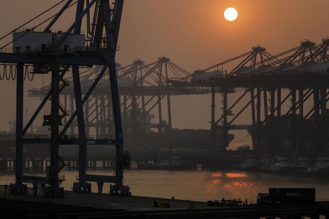 © Bloomberg. The sun sets over gantry cranes at the Jawaharlal Nehru Port, operated by Jawaharlal Nehru Port Trust (JNPT), in Navi Mumbai 