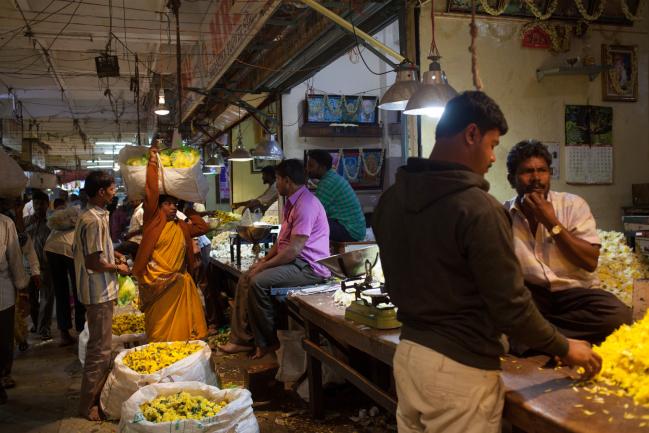 © Bloomberg. Vendors sell flowers at the Krishna Rajendra Market, also known as K.R. Market, in Bengaluru, India, on Thursday, July 19, 2018. India's central bank is on course to raise interest rates for a second consecutive policy meeting as it takes more decisive steps to rein in inflation and stem capital outflows. Photographer: Karen Dias/Bloomberg