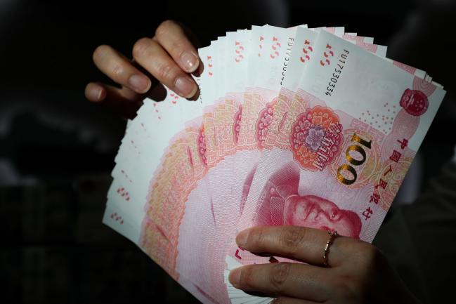 China's Yuan Weakens After PBOC Sets Fixing Closer to 7 a Dollar