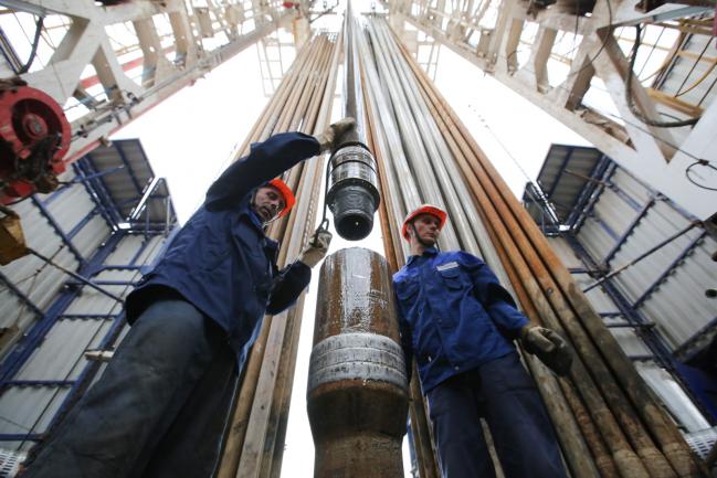 © Bloomberg. Workers secure drilling pipe sections on an oil drilling tower operated by Tatneft OAO near Almetyevsk, Russia, on Friday, July 31, 2015. 