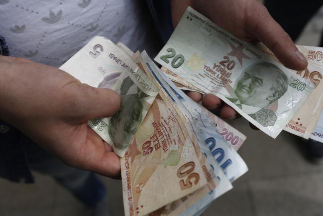 © Bloomberg. A customer counts Turkish lira banknotes after visiting a currency exchange in Istanbul, Turkey, on Friday, March 16, 2018. Photographer: Kostas Tsironis/Bloomberg