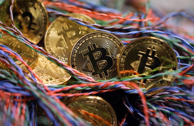 © Bloomberg. Bitcoins sit among twisted copper wiring inside a communications room at an office in this arranged photograph in London, U.K., on Tuesday, Sept. 5, 2017.