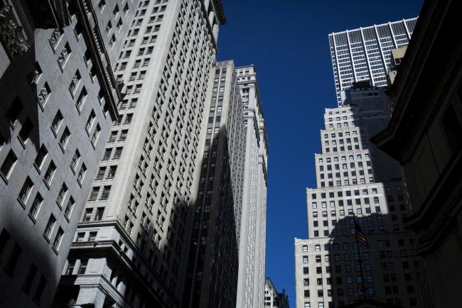 © Bloomberg. Buildings stand on Wall Street near the New York Stock Exchange (NYSE) in New York, U.S. 