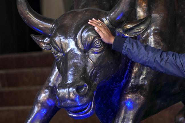 © Bloomberg. A man touches a bronze bull statue at the Bombay Stock Exchange (BSE) in Mumbai, India, on Thursday, Feb. 1, 2018. Prime Minister Narendra Modi's government ended a tax break on equity investments as it taps the stock market boom to boost its coffers. Photographer: Dhiraj Singh/Bloomberg
