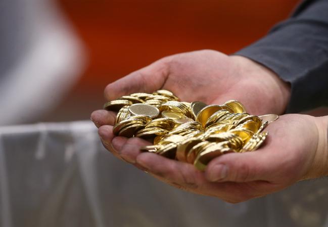 © Bloomberg. An employee holds a handful of blank coins at the Royal Canadian Mint Ltd. manufacturing facility in Winnipeg, Manitoba, Canada, on Monday, March 11, 2019. The Canadian dollar was steady against the greenback amid rising oil prices and mixed versus G-10 currencies as traders awaited domestic home price data Wednesday and a speech by the Bank of Canada's Carolyn Wilkins on Thursday. Photographer: Shannon VanRaes/Bloomberg