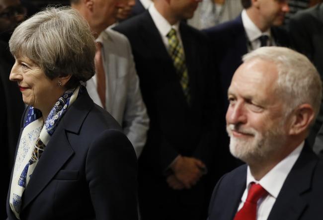 © Bloomberg. LONDON, UNITED KINGDOM - JUNE 21: British Prime Minister Theresa May (L) and Leader of the Labour Party Jeremy Corbyn walk through the House of Commons to attend the the State Opening of Parliament taking place in the House of Lords at the Palace of Westminster on June 21, 2017 in London, United Kingdom. This year saw a scaled-back State opening of Parliament Ceremony with the Queen arriving by car rather than carriage and not wearing the Imperial State Crown or the Robes of State. (Photo by Kirsty Wigglesworth - WPA Pool/Getty Images)