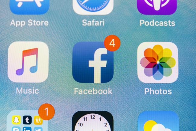 © Bloomberg. The Facebook Inc. application icon is displayed on an Apple Inc. iPhone in an arranged photograph taken in New York, U.S., on Thursday, July 26, 2018. Facebook shares plunged 19 percent Thursday after second-quarter sales and user growth missed Wall Street estimates. Photographer: Johannes Berg/Bloomberg