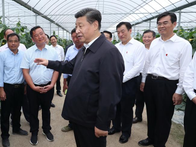 © Bloomberg. Chinese President Xi Jinping, also general secretary of the Communist Party of China Central Committee and chairman of the Central Military Commission, talks with villagers at an industrial park for planting selenium-rich vegetables in Yudu County during an inspection tour of east China's Jiangxi Province. Xi on Monday visited an old revolutionary base area in the south of Jiangxi Province during the inspection. 
