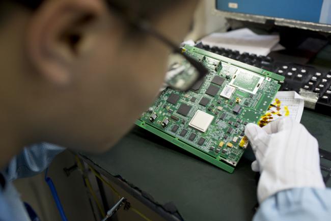© Bloomberg. An employee inspects a circuit board in a manufacturing facility at ZTE Corp.'s headquarters in the Nanshan district of Shenzhen, China, on Thursday, Aug. 7, 2014. ZTE, a Chinese maker of telecommunications equipment and systems, is scheduled to report second quarter earnings on Aug. 20.