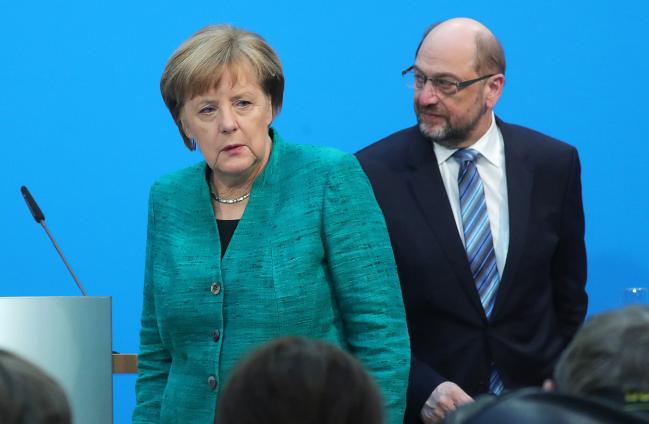 © Bloomberg. Angela Merkel, Germany's chancellor and leader of the Christian Democratic Union (CDU) party, left, and Martin Schulz, leader of the Social Democrat Party (SPD), exit the stage following a news conference at the Christian Democratic Union (CDU) headquarters in Berlin, Germany.
