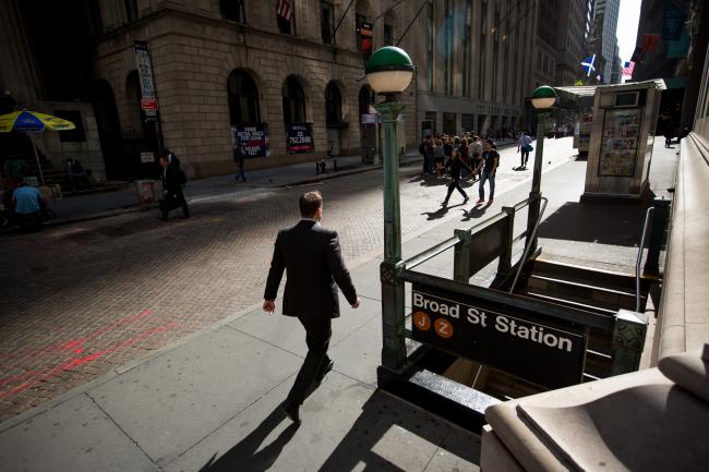 © Bloomberg. A pedestrian walks along Wall Street near the New York Stock Exchange (NYSE) in New York, U.S., on Monday, Sept. 11, 2017. The record-setting rally in U.S. stocks is back on. After a five-week hiatus without any all-time highs, the S&P 500 Index climbed as much as 0.9 percent to 2,483.81 and was poised for its 31st record close this year. Photographer: Michael Nagle/Bloomberg