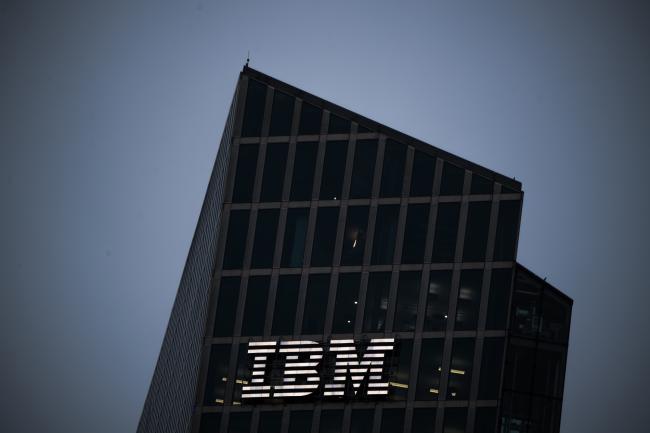 © Bloomberg. A logo sits illuminated on the International Business Machines Corp. (IBM) Watson cognitive computing platform Internet of Things (IoT) center, at the IoT center in Munich, Germany, on Thursday, Aug. 10, 2017.  